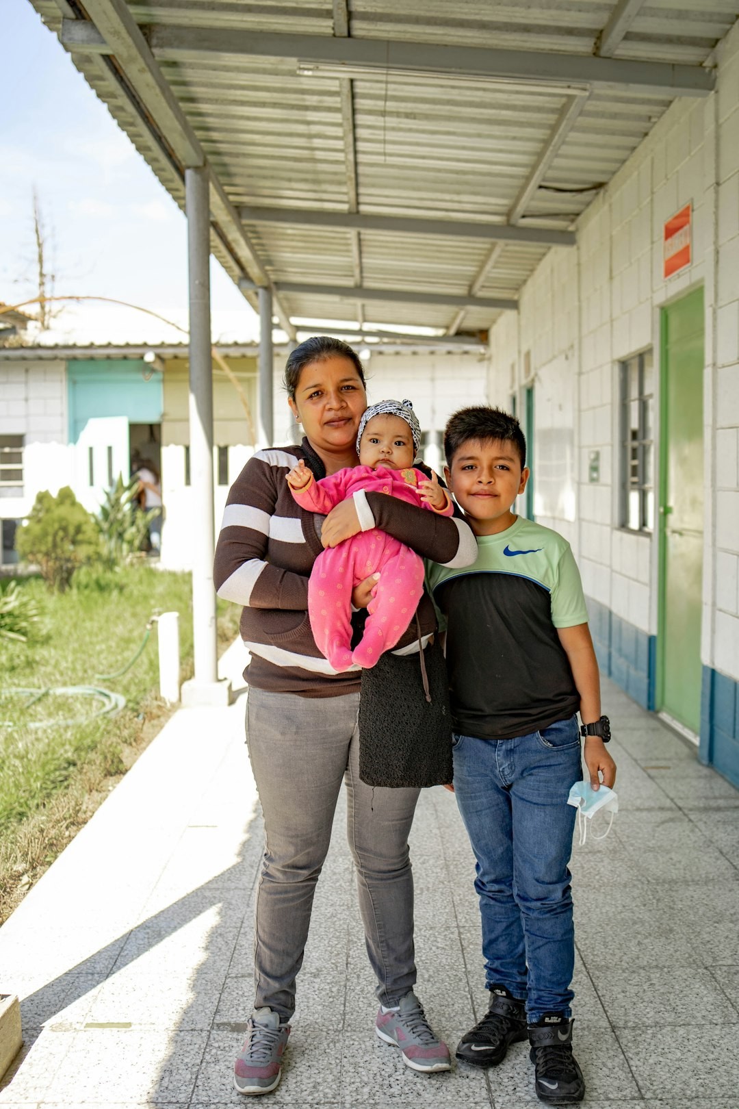 A woman and two children standing outside of a building